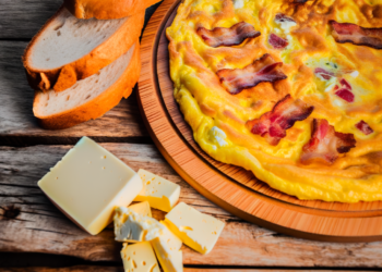 picture of serbian omlette with bacon and serbian bread and cheesse on rustic wooden table