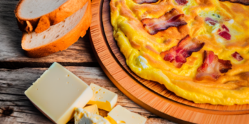 picture of serbian omlette with bacon and serbian bread and cheesse on rustic wooden table